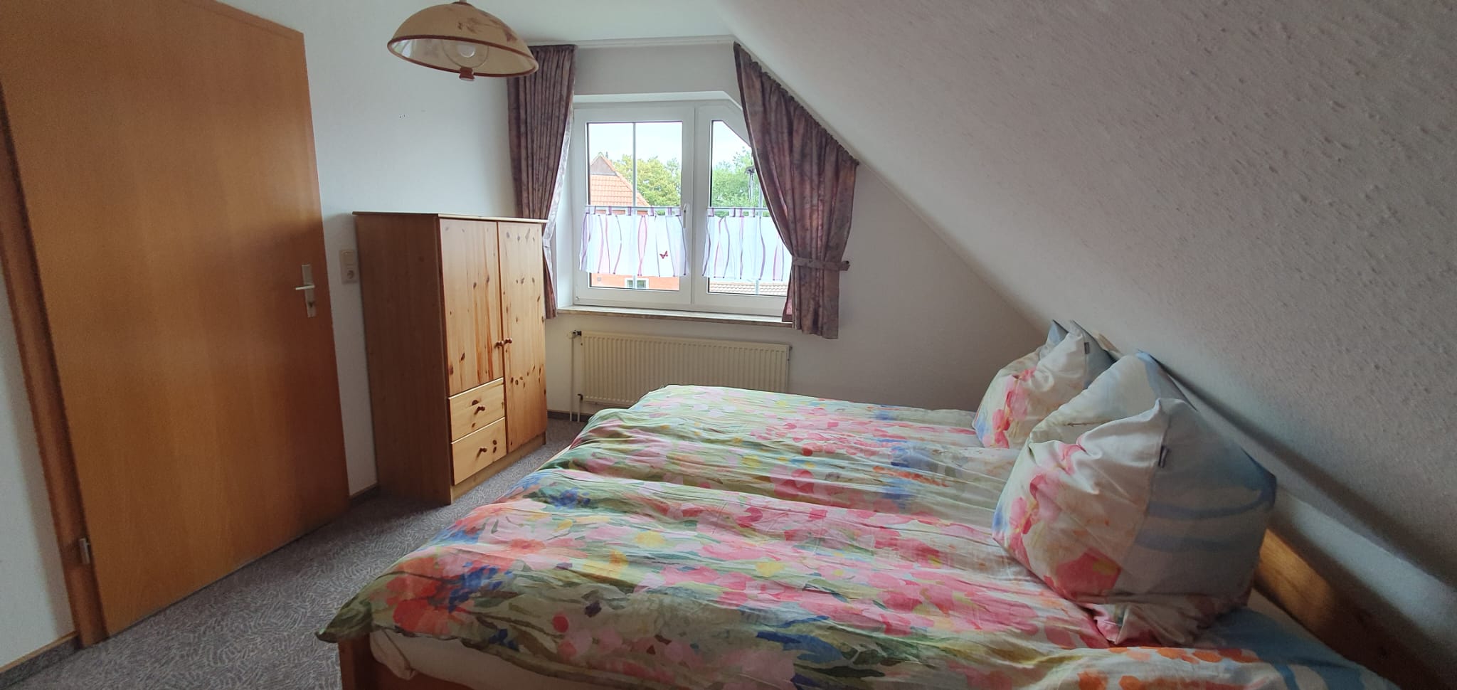 Schlafzimmer mit Doppelbett unter der Dachschräge